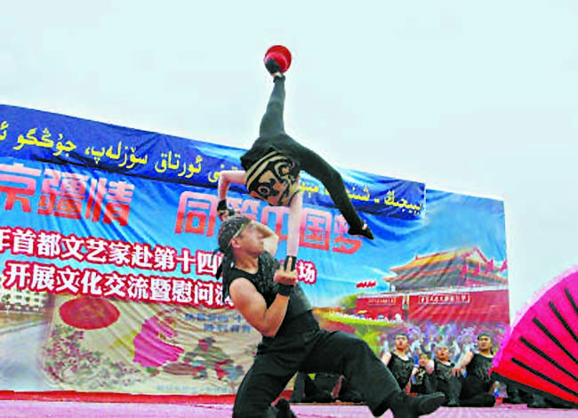 中国杂技团国际金奖节目《十三人顶碗》惊险刺激。13位演员刚出访非洲回国一周便来到和田演出。“底座儿”高学峰带着腰伤依然场场登台。