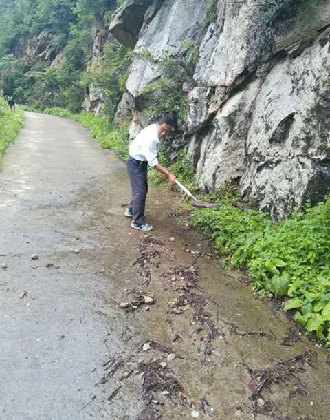 图5雨后，卢自有在清理家乡的路