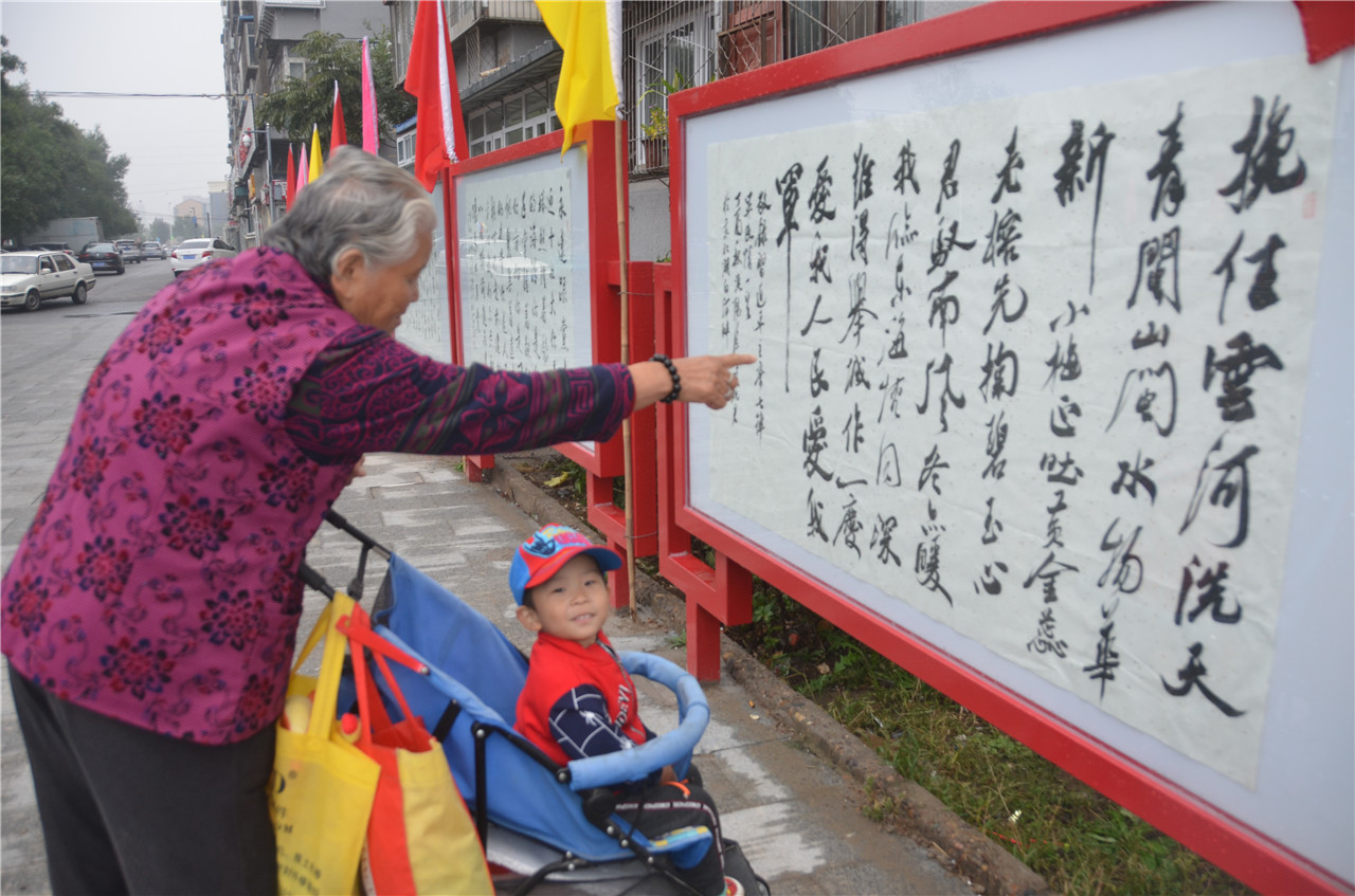 奶奶带着孙子聚精会神看书作，“小来往这瞧”。