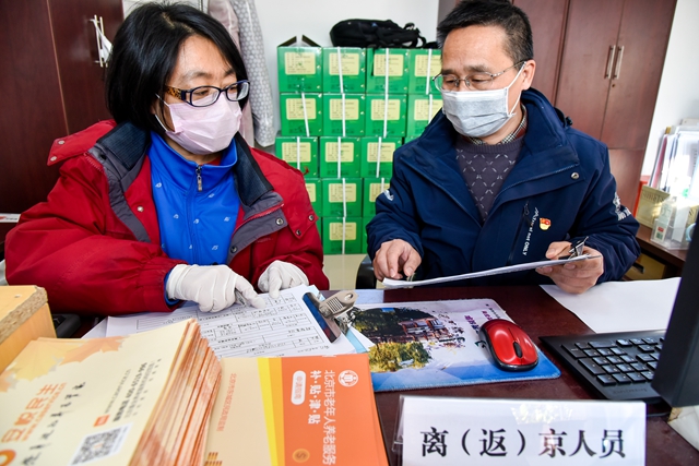 张传东-前门街道大江社区工作人员统计核对防控登记报表