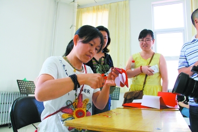 孙氏剪纸传人孙春播在林西县教当地群众剪纸，此次草原行共有四位民间艺术家为当地群众带去了剪纸、泥人、彩绘脸谱等民间艺术。