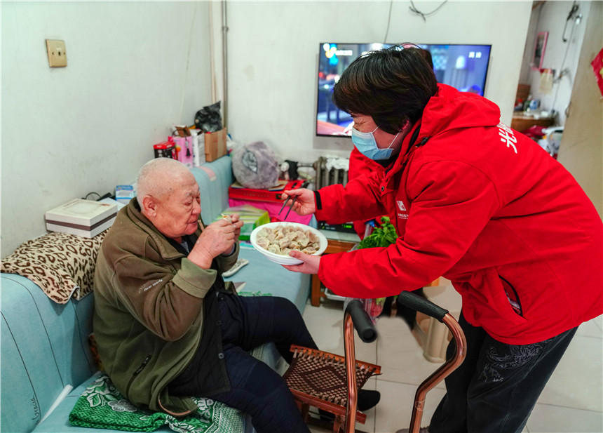 东兴一区党支部书记王振在疫情期间为独居老人送上煮好的水饺。吴晓纪摄