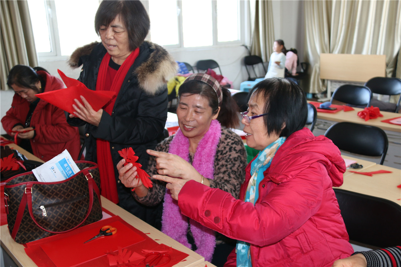 2社区居民在认真学习剪纸