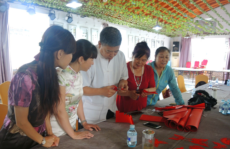 张家口剪纸大师高佃亮为两地艺术家讲解剪纸（任海濛摄）